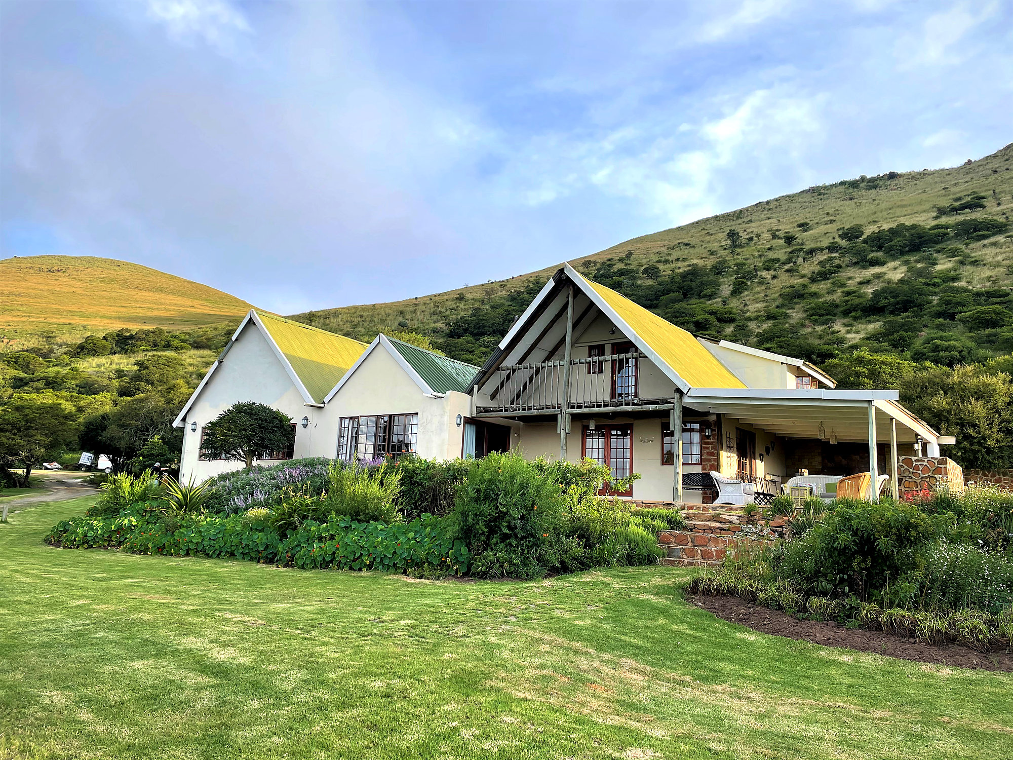 The Main House with its yellow roof and green lawn